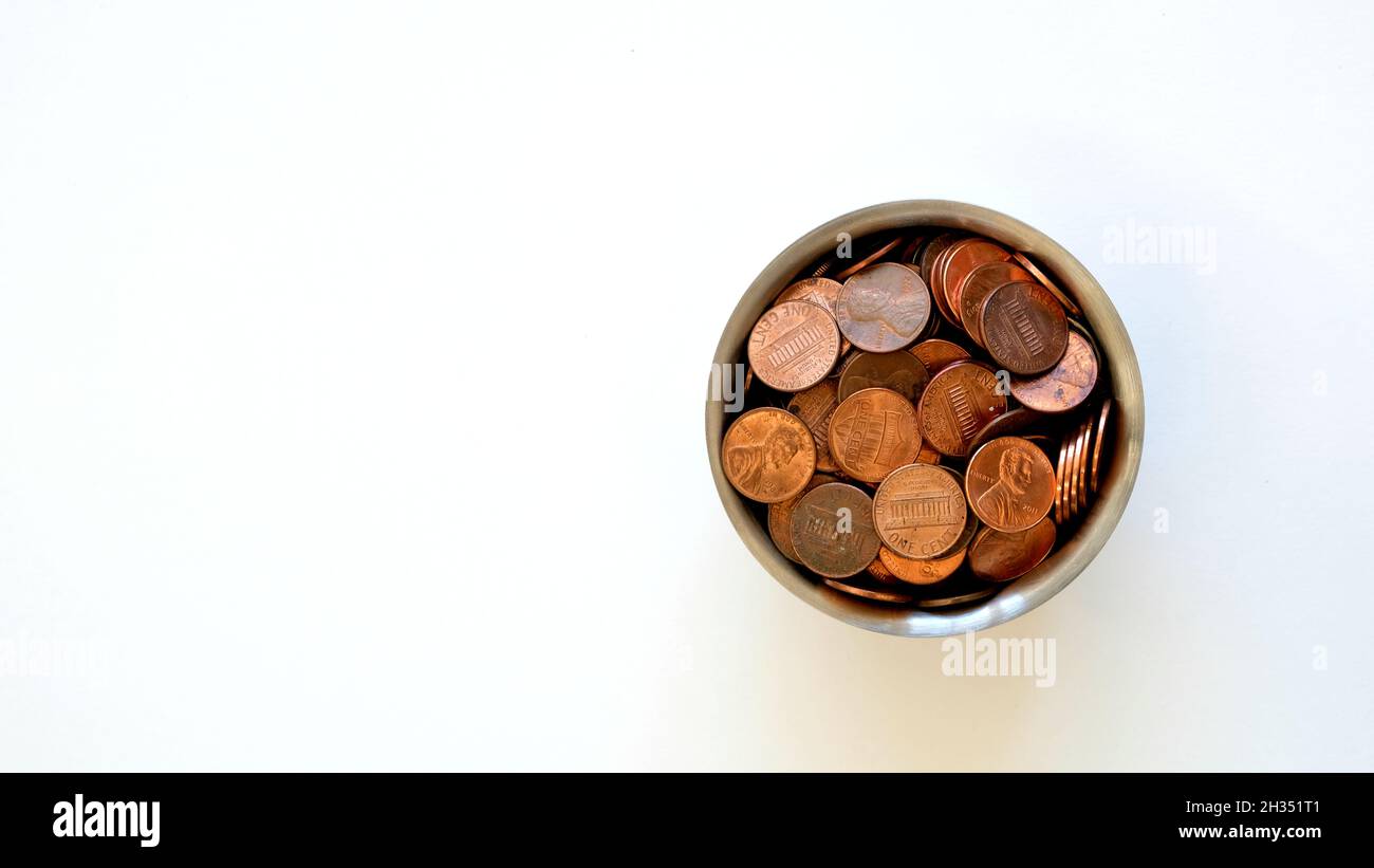 Sortierte Auswahl an aktuellen verwenden American Pennies in einem Chrom-Tasse auf einem weißen Hintergrund mit Copy Space; U.S. Penny; Münzen, Geld, Währung. Stockfoto