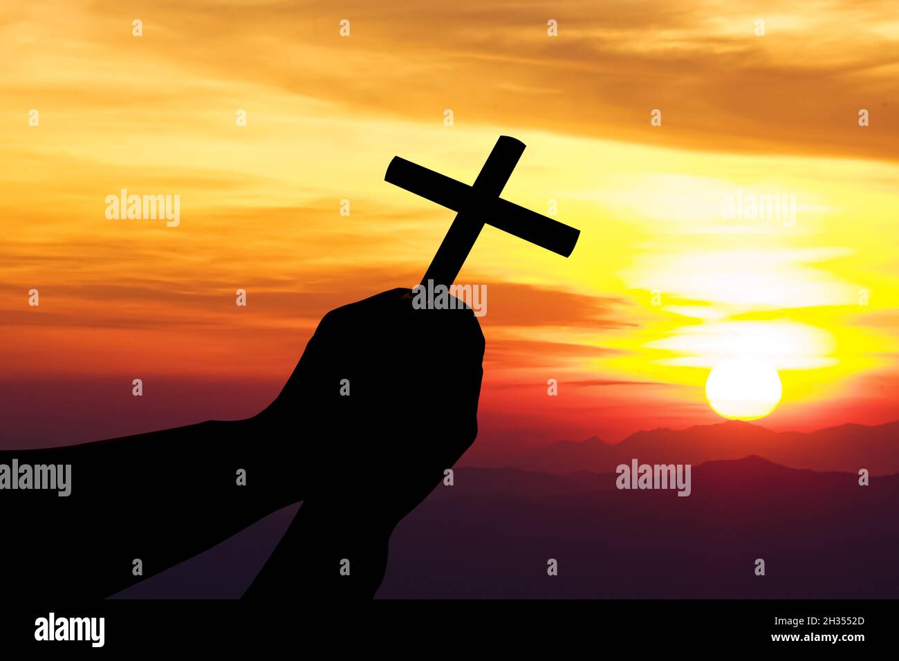 Silhouette des Kreuzes in der menschlichen Hand, der Hintergrund ist der Sonnenaufgang, das für die christliche Religion, göttliche, himmlische, himmlische oder gott Konzept Stockfoto