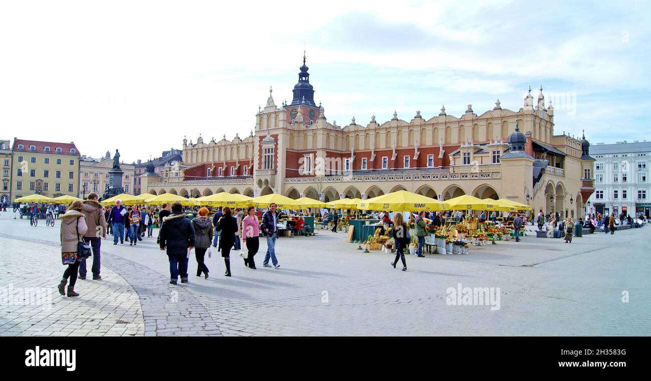 Ein überfüllter Frühlingstag auf dem Hauptmarktplatz in der Altstadt von Krakau, Polen. Der historische Platz und die Tuchhalle sind Wahrzeichen, die ihr lokales und Weltkulturerbe bestätigen. Stockfoto