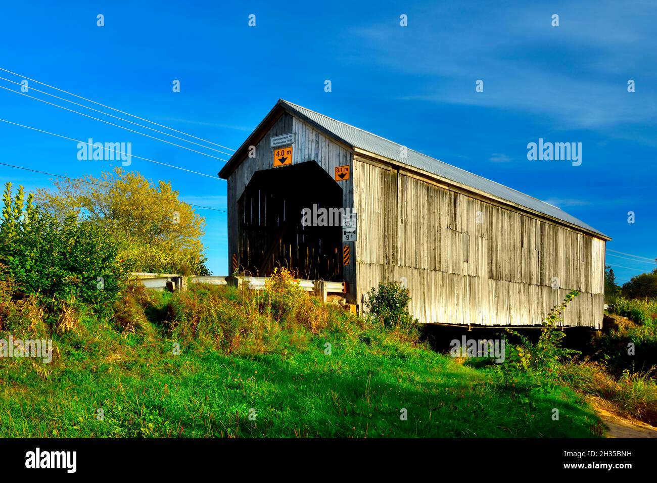 Eine herbstliche Landschaftsaufnahme von Kennebecasis #9 überdachte Brücke auf einer Landstraße bei Plumweseep New Brunswick Canada. Stockfoto