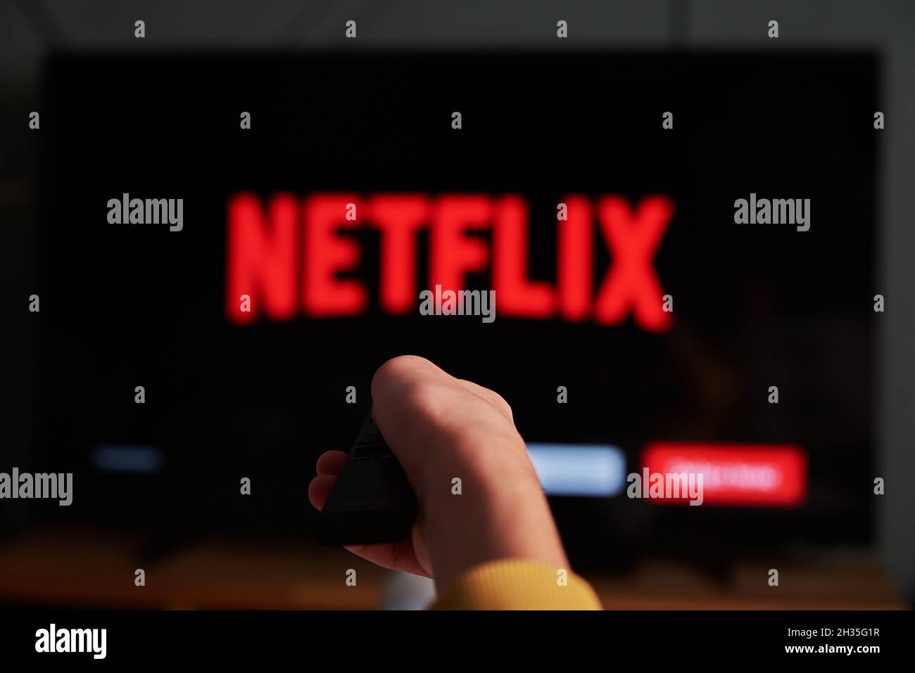 Online-Streaming-Dienst. Boy halten Sie die Fernbedienung in der Hand und das Fernsehgerät mit DEM NETFLIX Service-Logo. Katy Wroclawskie, Polen - 25. Oktober 2021 Stockfoto