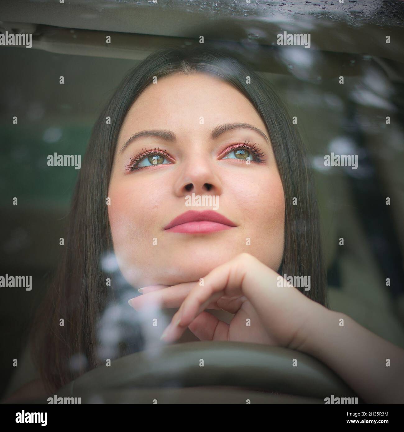 Junge Frau denkt im Auto Stockfoto