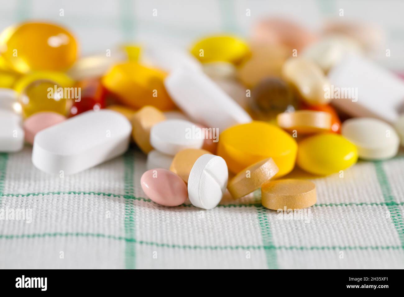 Viele bunte Pillen auf einer Serviette. Diese abwechslungsreichen Tabletten haben verschiedene Formen und Farben. Stockfoto