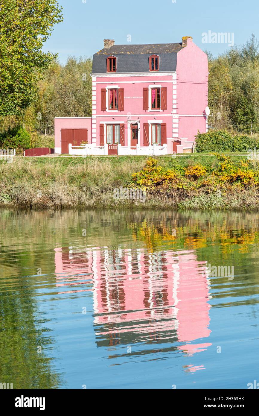 Rosa Haus am Rand des Kanals, Reflexionen auf dem Wasser. Saint-Valery, Somme-Bucht, Frankreich Stockfoto