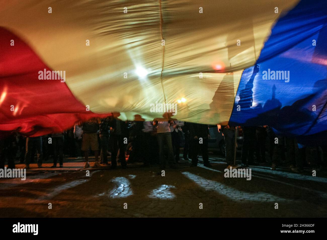 Bukarest, Rumänien, 7. April 2009: Während einer großen pro-republikanischen Ra entwirren Demonstranten auf dem Universitätsplatz in Bukarest eine riesige rumänische Flagge Stockfoto