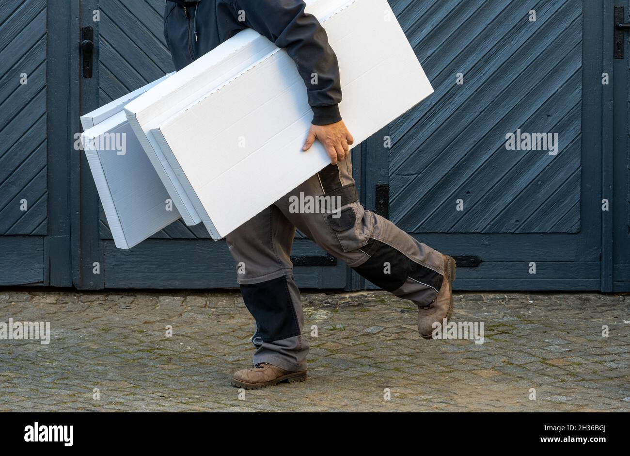 Mann läuft, hält Stapel von Kisten, Seitenansicht Stockfoto