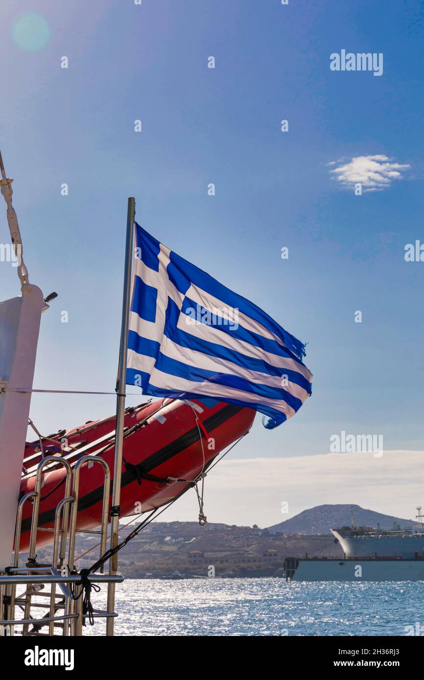 Griechische Flagge. Isoliert. Himmel im Hintergrund. Blau-weiße Nationalflagge, die im Wind neben Schiffen weht. Stockbild. Stockfoto