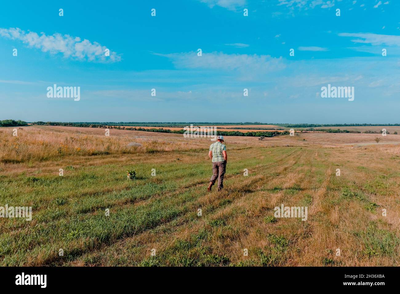 Eine Frau geht an einem sonnigen, warmen Tag entlang einer großen, geräumigen Landung. Stockfoto