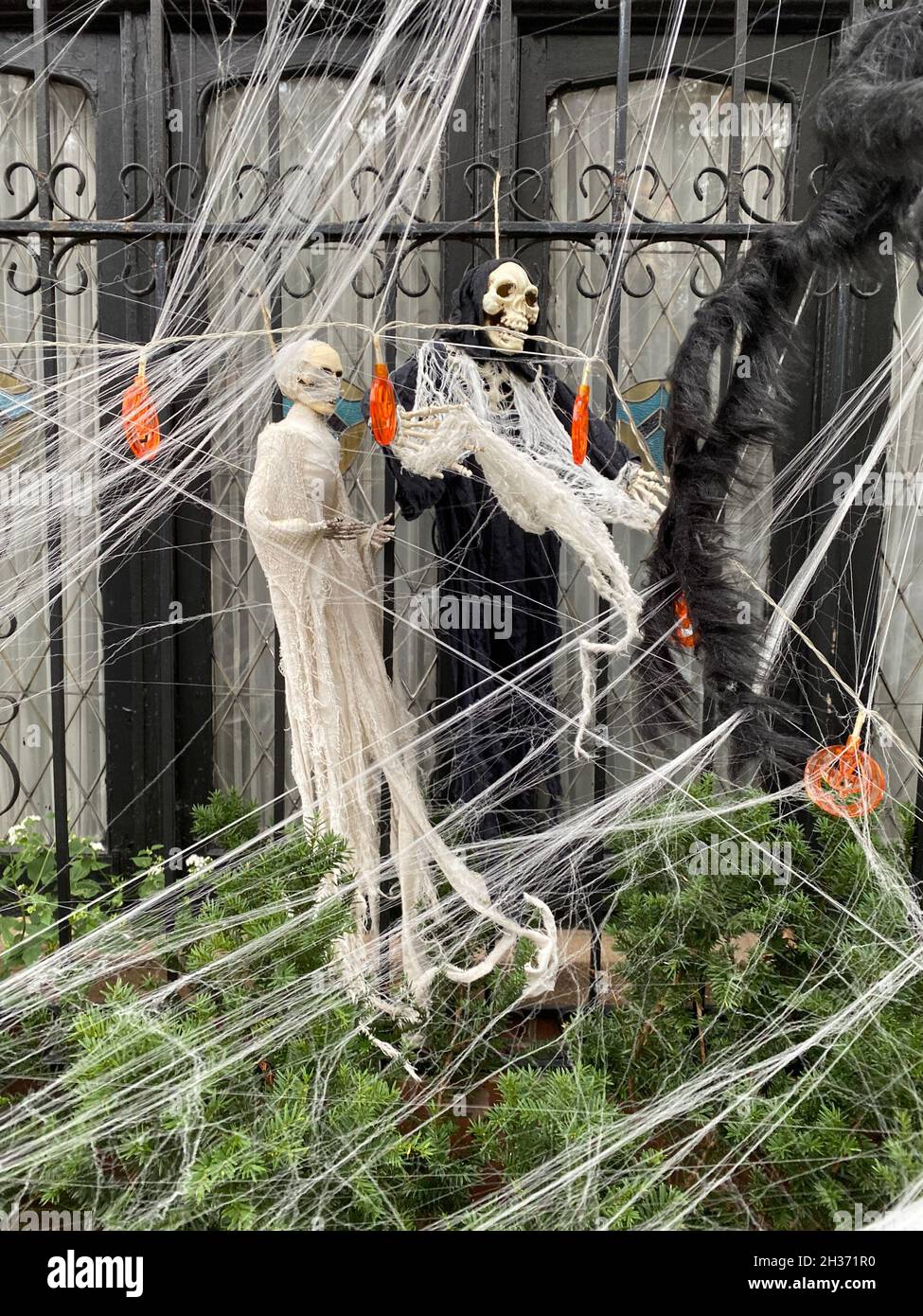 Gruselige Geister und Spinnweben für Halloween im Vorgarten eines Hauses in Brooklyn, New York. Stockfoto