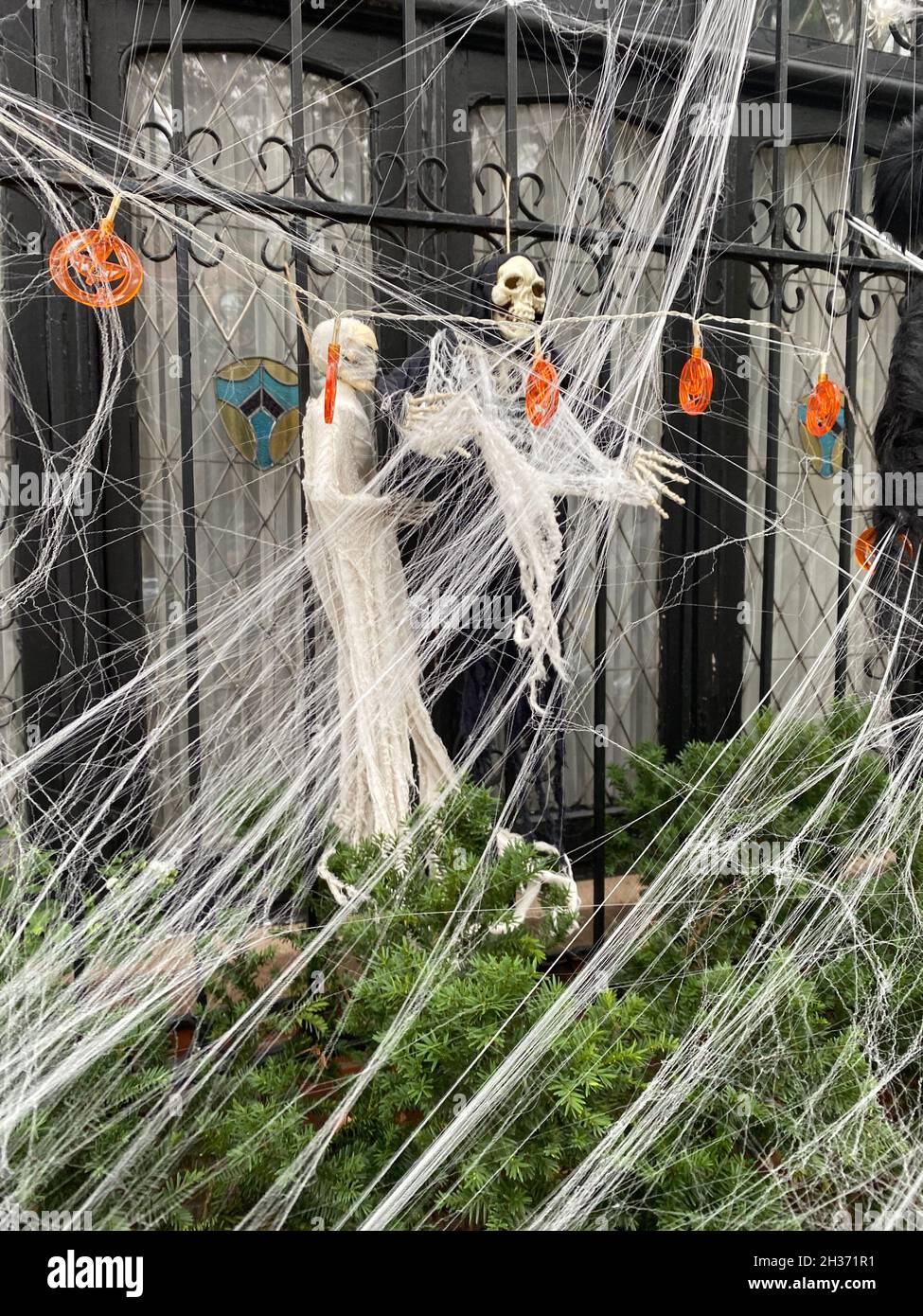 Gruselige Geister und Spinnweben für Halloween im Vorgarten eines Hauses in Brooklyn, New York. Stockfoto