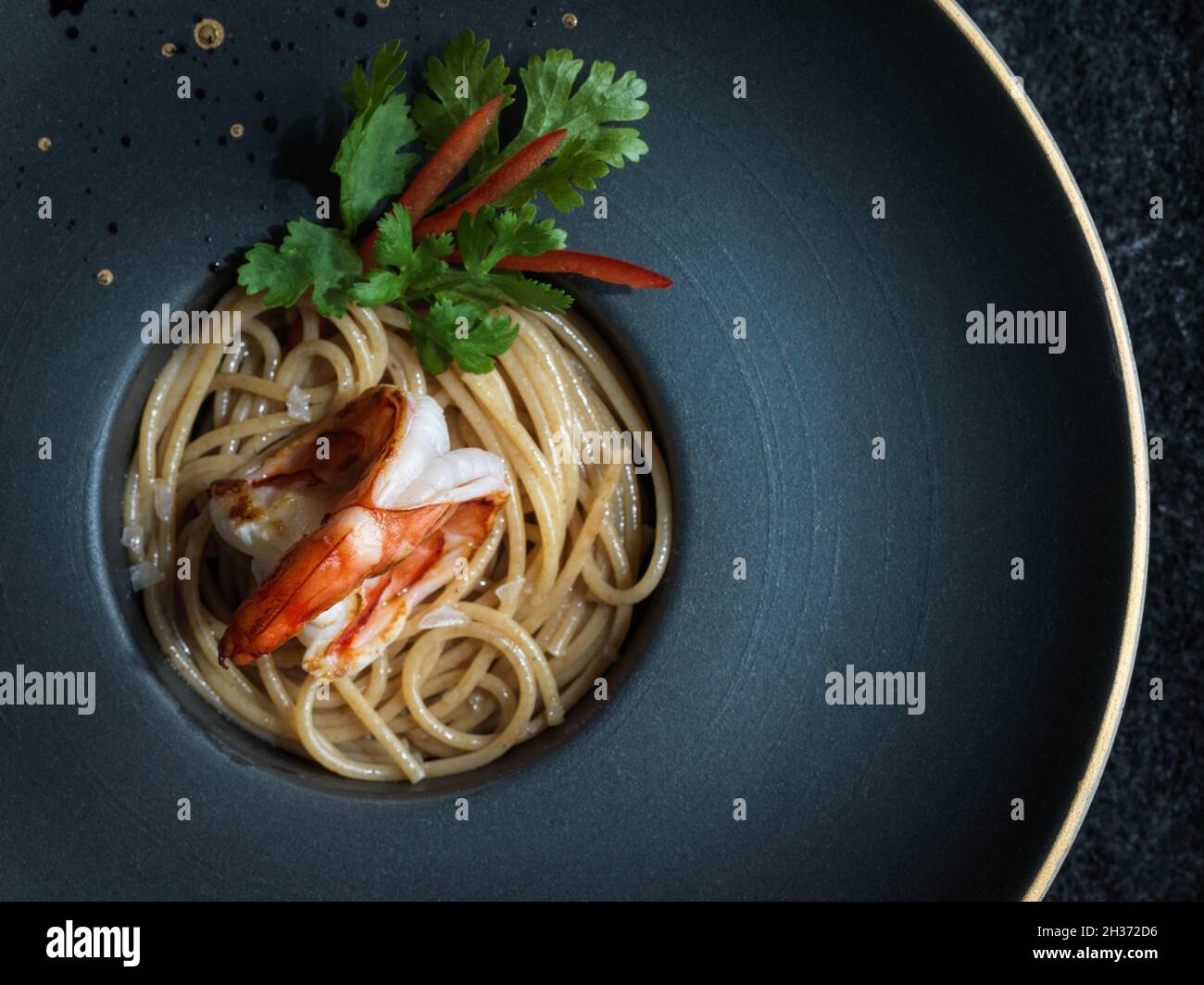 Tigergarnele auf gebutterten Spaghetti mit Koriander und rotem Pfeffer Stockfoto