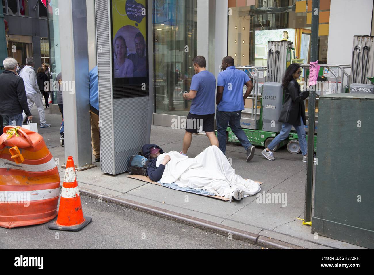 Ein Obdachloser, der sich direkt an der 5th Avenue in Midtown Manhattan niedergelassen hat. NYC Stockfoto