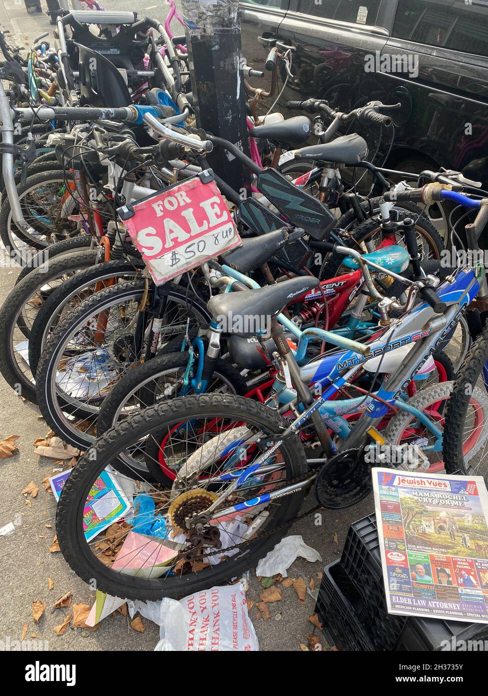 Stapel von zusammengeketteten Fahrrädern zum Verkauf auf dem Bürgersteig in Borough Park, Brooklyn, New York. Stockfoto