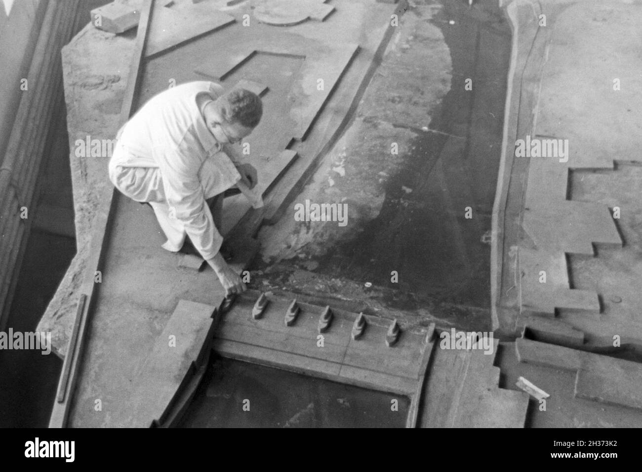 Im Flußbau Laboratorium in Karlsruhe wird ein Modell eines Staudamms durch einen Modellbauer modelliert, Deutschland 1930er Jahre. Am Fluss Engineering Laboratory in Karlsruhe ein Modell eines Flusses Schwall von einem Modellbauer konstruiert wird, Deutschland 1930. Stockfoto