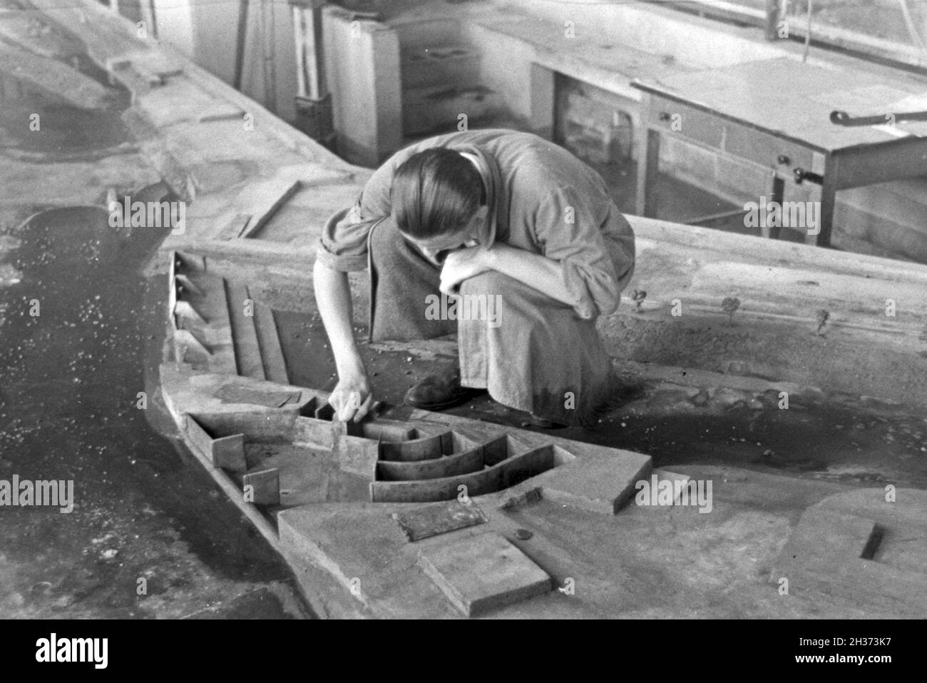 Im Flußbau Laboratorium in Karlsruhe wird ein Modell eines Staudamms durch einen Modellbauer modelliert, Deutschland 1930er Jahre. Am Fluss Engineering Laboratory in Karlsruhe ein Modell eines Flusses Schwall von einem Modellbauer konstruiert wird, Deutschland 1930. Stockfoto