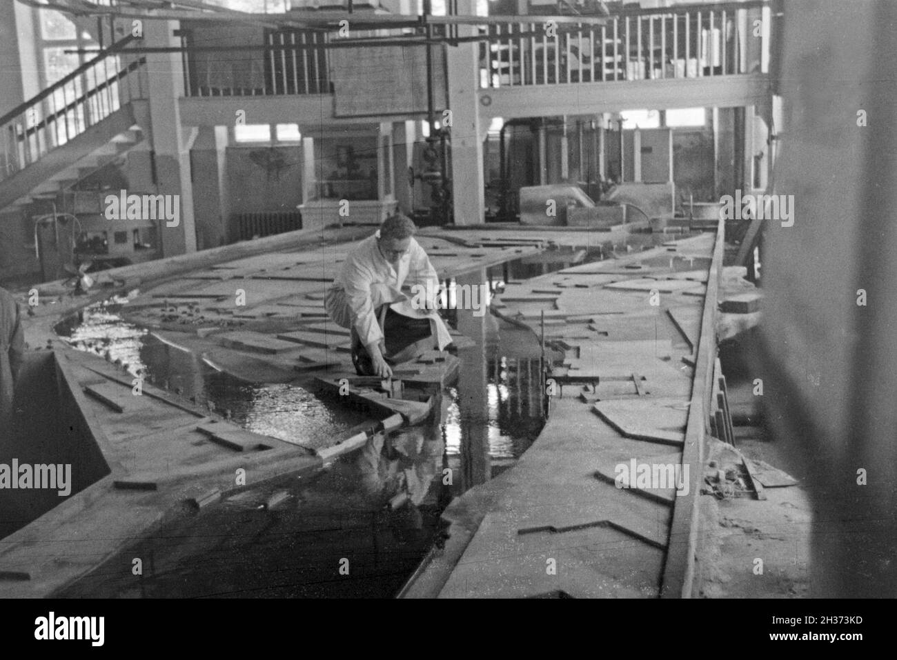 Im Flußbau Laboratorium in Karlsruhe wird ein Modell eines Staudamms durch einen Modellbauer modelliert, Deutschland 1930er Jahre. Am Fluss Engineering Laboratory in Karlsruhe ein Modell eines Flusses Schwall von einem Modellbauer konstruiert wird, Deutschland 1930. Stockfoto