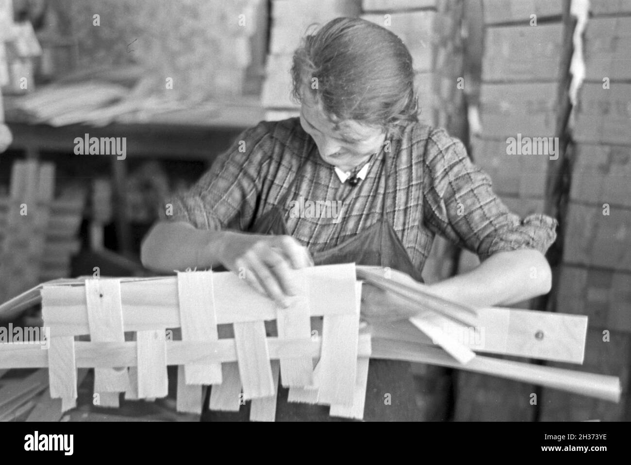 Arbeiterin in der Bühler Spankorbfabrik, sterben sterben sterben Körbe für die Erdbeerernte liefert, Deutschland 1930er Jahre. Arbeiterin in der Fabrik gebäude der Korb Fabrik, die Herstellung der Körbe für die Erdbeere Ernte in Bühl, Deutschland 1930. Stockfoto