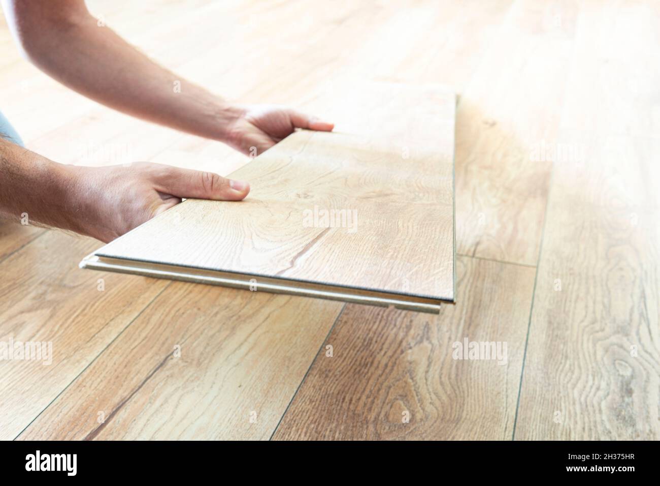 Verlegung von Laminatböden, Nahaufnahme. Austausch von beschädigten Laminatböden. Renovierung in der Wohnung. Parkettauswahl Stockfoto