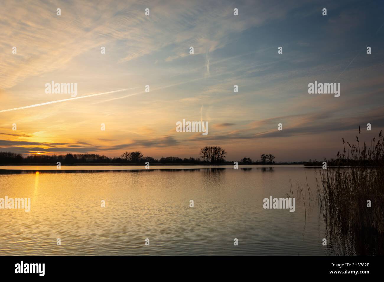 Sonnenuntergang und Wolken über einem ruhigen See Stockfoto