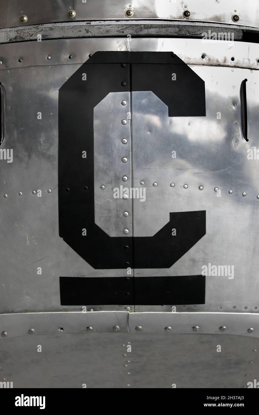 Der Großbuchstabe C auf der Seite des silbernen Metallrufs eines Flugzeugs Stockfoto