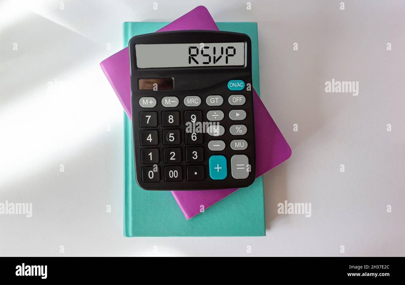 Rechner mit Text RSVP auf dem Display. Notizblöcke liegen auf weißem Hintergrund. Für Text platzieren Stockfoto