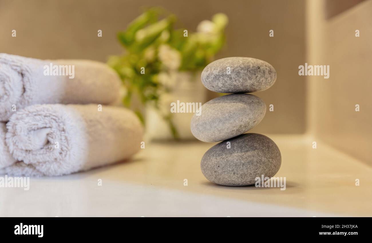 Zen-Steine, glatte Kieselsteine Pyramide gestapelt Gleichgewicht, Spa-Innenraum Hintergrund. Ganzheitliches Naturtherapie- und Wellnesskonzept Stockfoto