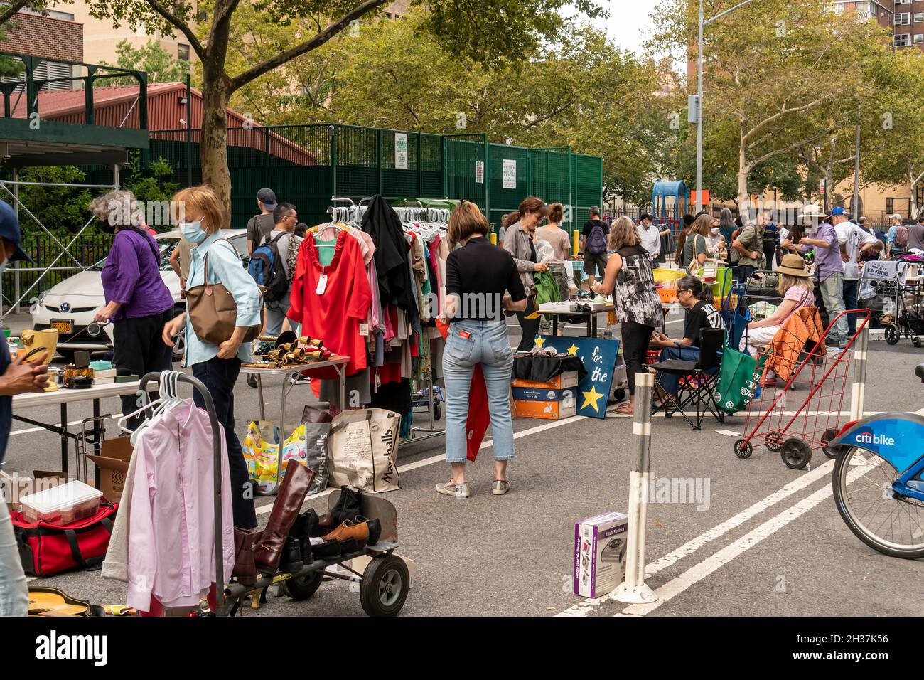 Am Samstag, den 16. Oktober 2021, suchen Käufer nach Schnäppchen auf dem alljährlichen Penn South Flohmarkt im New Yorker Stadtteil Chelsea. Der Flohmarkt, der aufgrund der Pandemie im vergangenen Jahr in der Pause war, erscheint wie Brigadoon, nur einmal im Jahr, und die Bewohner der 20 erbauten Penn South-Kooperativen haben eine aufwändige Kleiderreinigung. Shopper aus der ganzen Stadt kommen auf den Flohmarkt, der Tausende auf der Durchreise anzieht. (© Richard B. Levine) Stockfoto