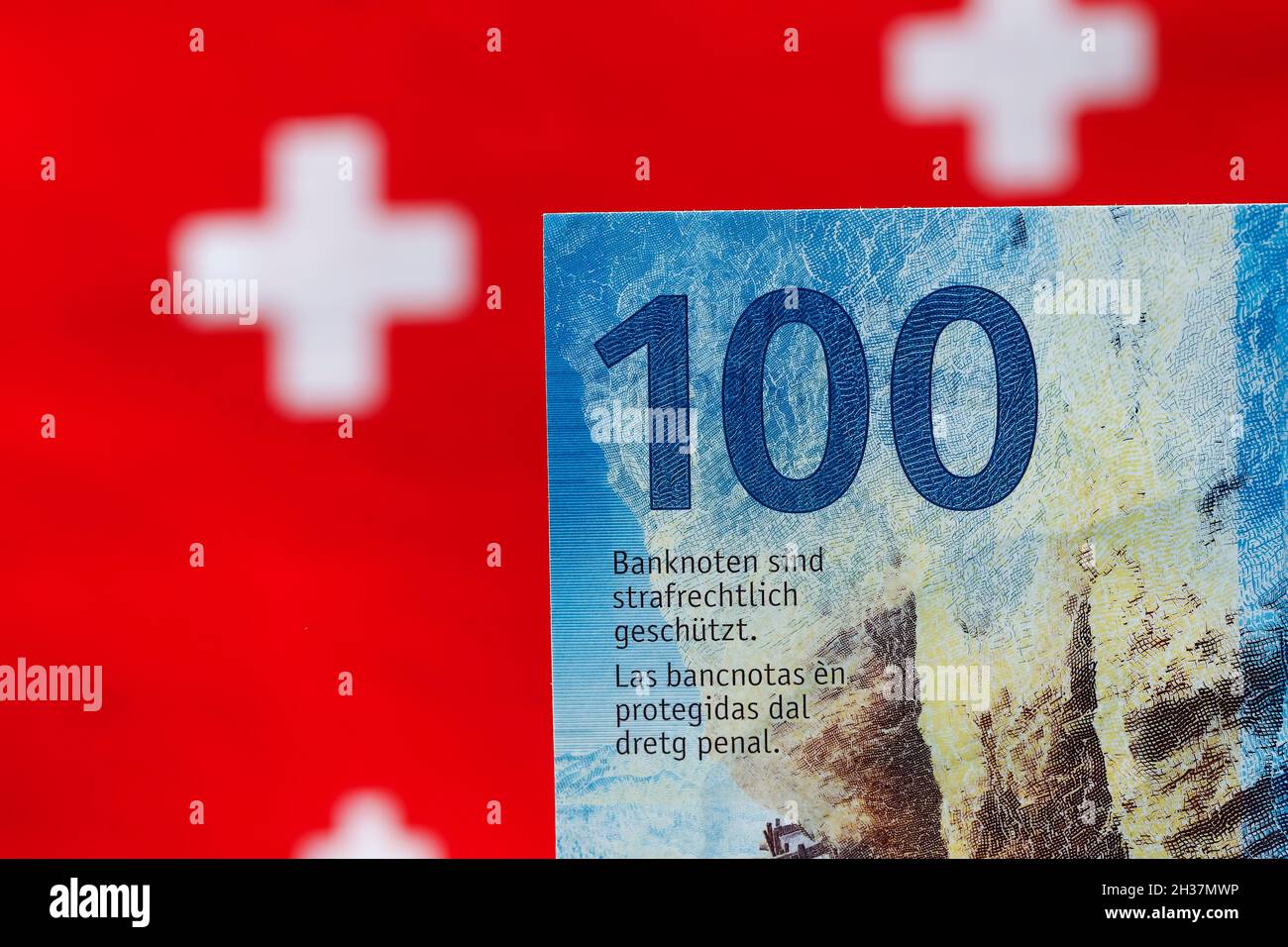 Eine Banknote von hundert Schweizer Franken und die Flaggensymbole sind im Hintergrund zu sehen. Dies ist die achte Serie von Schweizer Banknoten, die in c Stockfoto