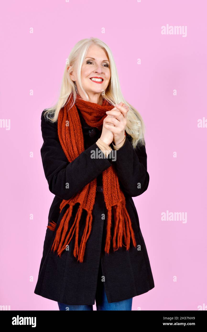Attraktive Blonde Lady auf rosa Hintergrund klatschende Hände genommen Stockfoto