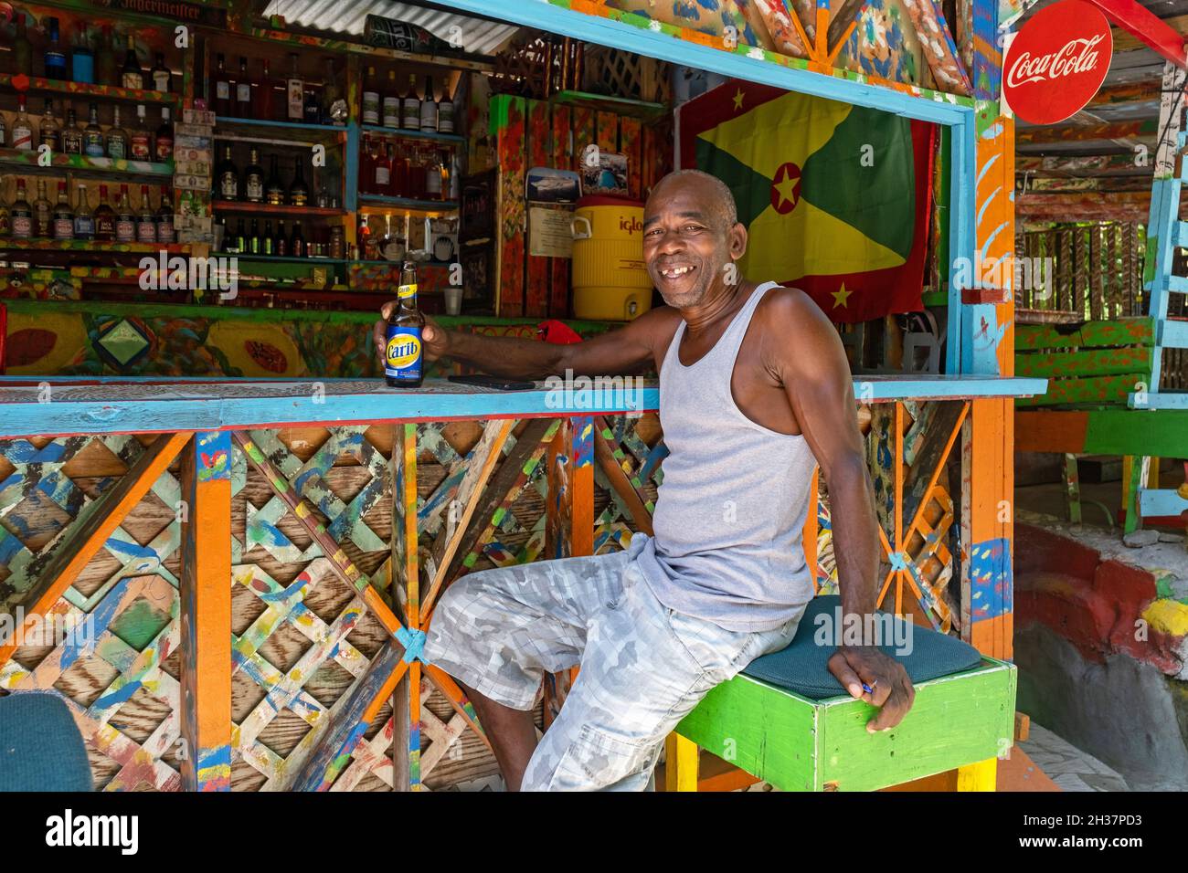 Heimischer Schwarzer trinkt Carib Bier in Charlie's Bar auf Happy Hill, Saint George an der Westküste der Insel Grenada, Karibik Stockfoto