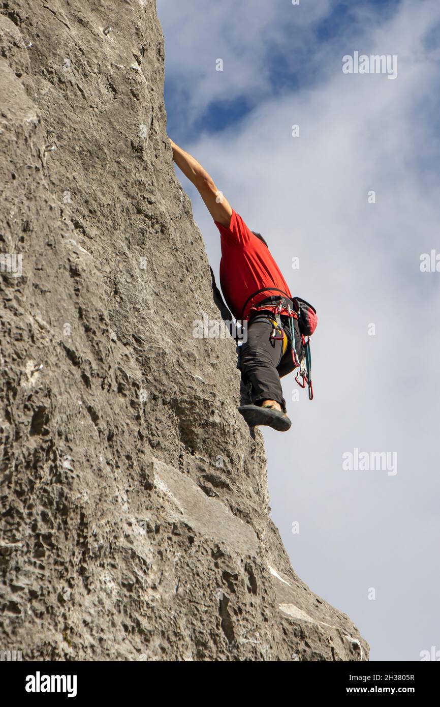 Junger Sportler klettert auf der Kalnik, Kroatien, auf eine natürliche hohe Felswand Stockfoto