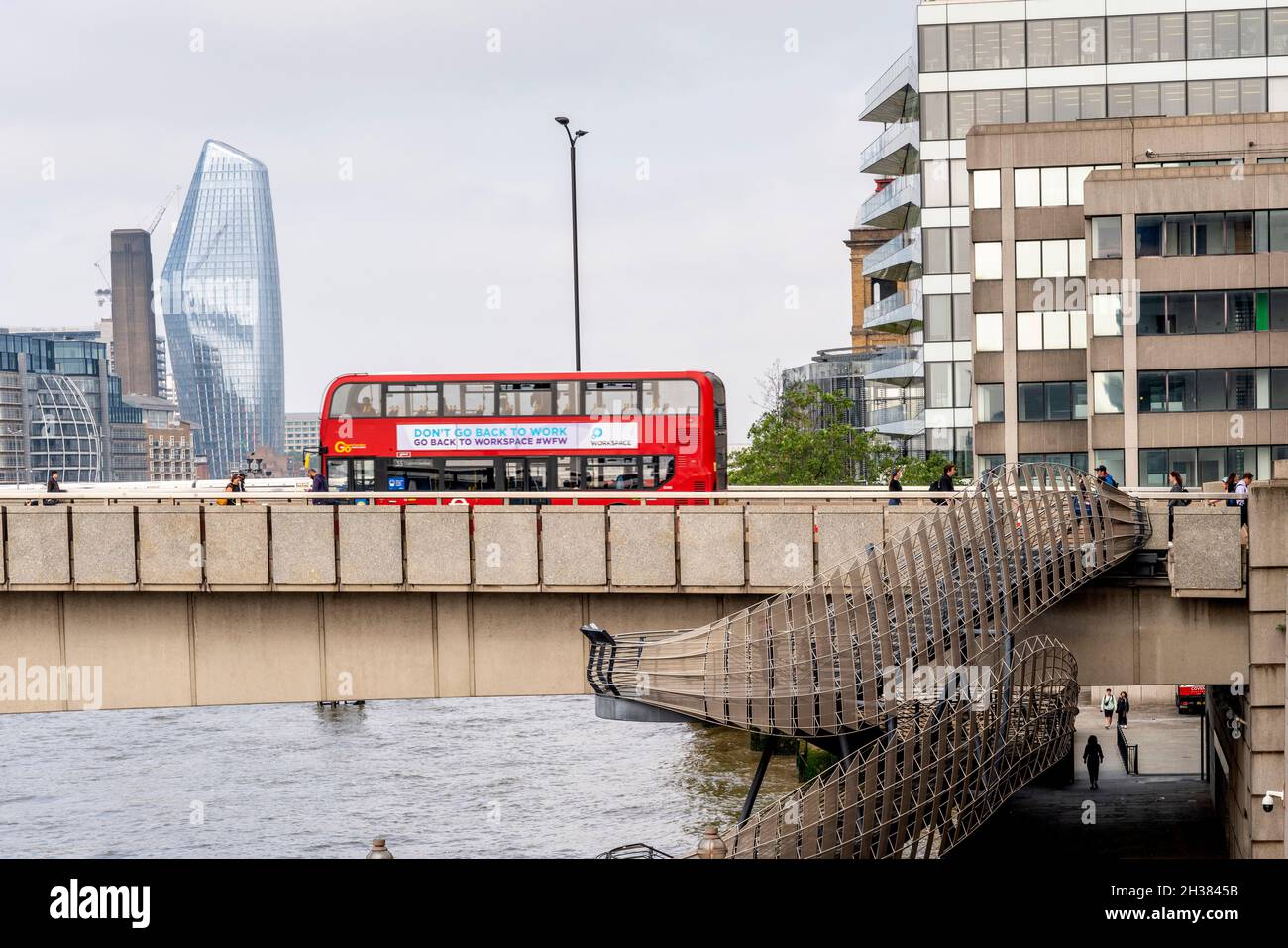 Ein traditioneller Red London Bus überquert die London Bridge mit der New London Bridge Staircase im Vordergrund, London, UK. Stockfoto