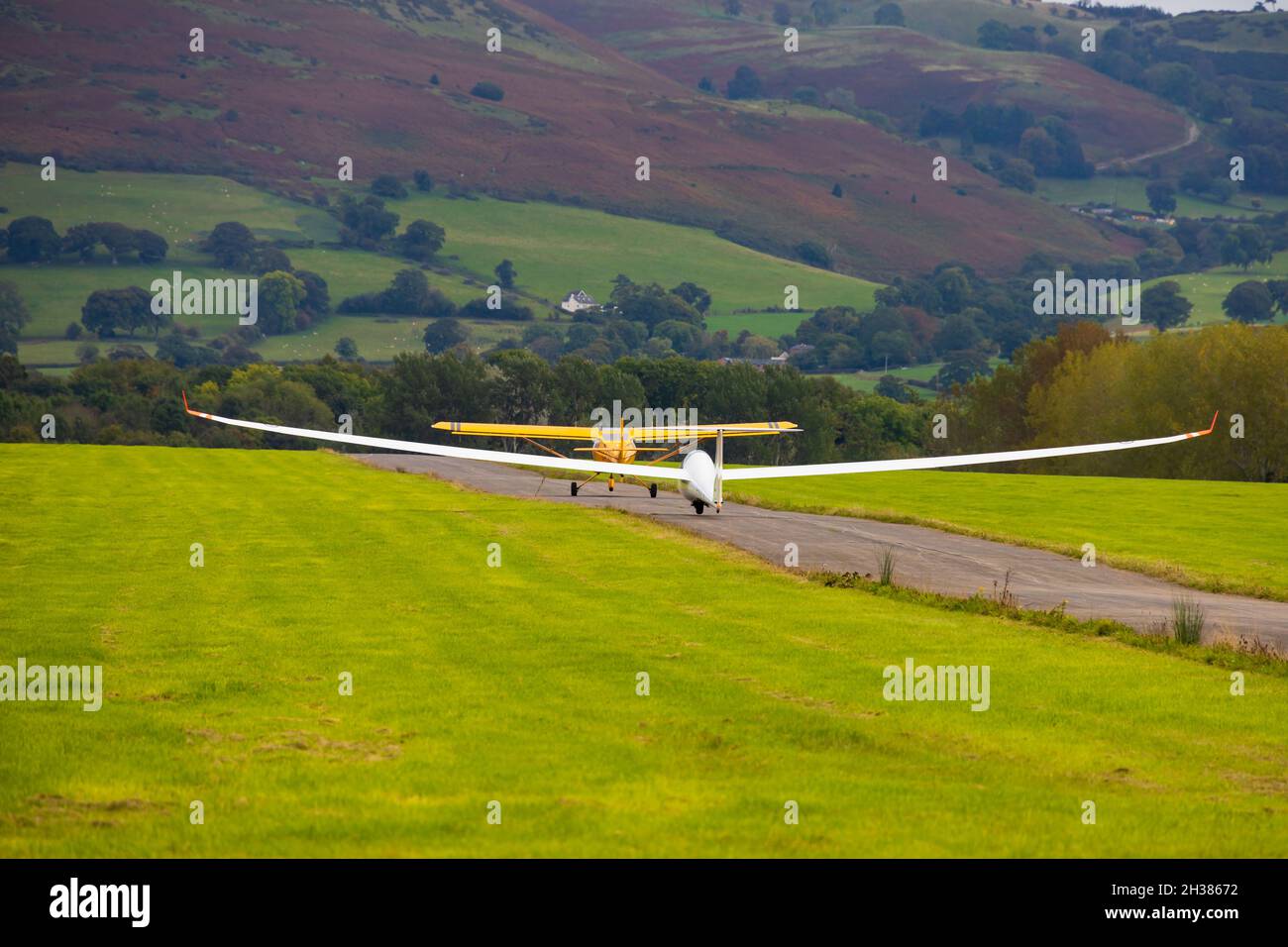 Schempp-Hirth Duo Discus startet mit dem Flugzeug hinter einem gelben Eurofox-Schlepper. Lleweni Parc, Denbighshire, Wales. Stockfoto