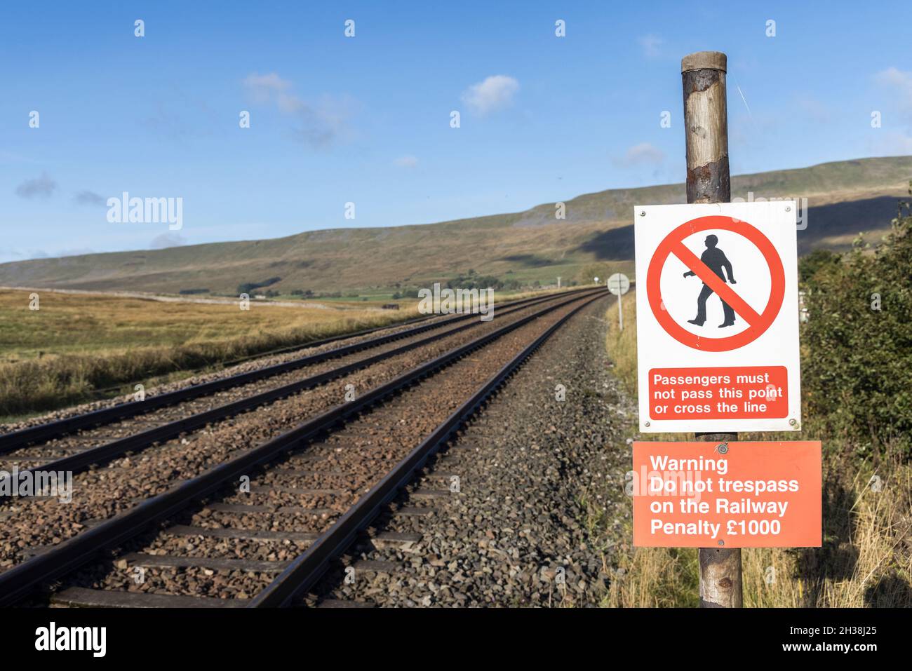 Warnschild, dass man die Bahn nicht am Bahnhof Ribblehead, Yorkshire Dales, Großbritannien, betreten darf Stockfoto