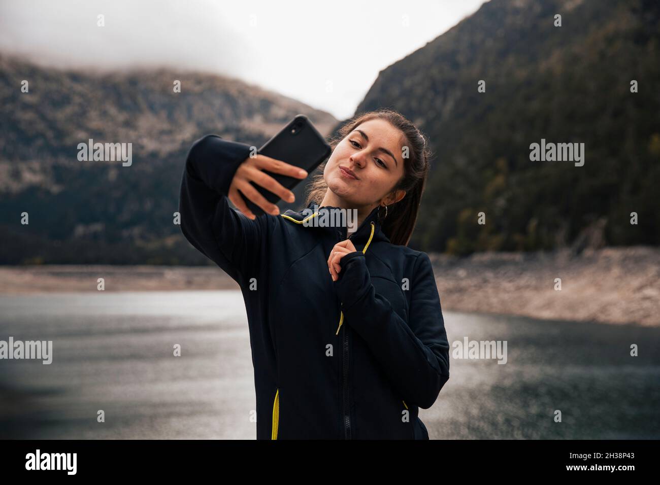 Mädchen nimmt ein Selfie in den Bergen mit ihrem Handy Stockfoto