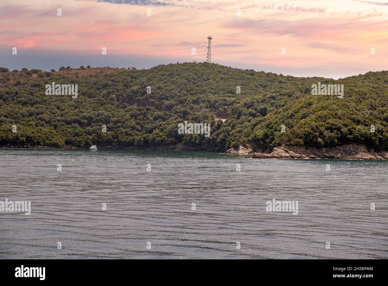 Ein Boot im Ionischen Meer und der südlichen Felsküste Albaniens. Stockfoto