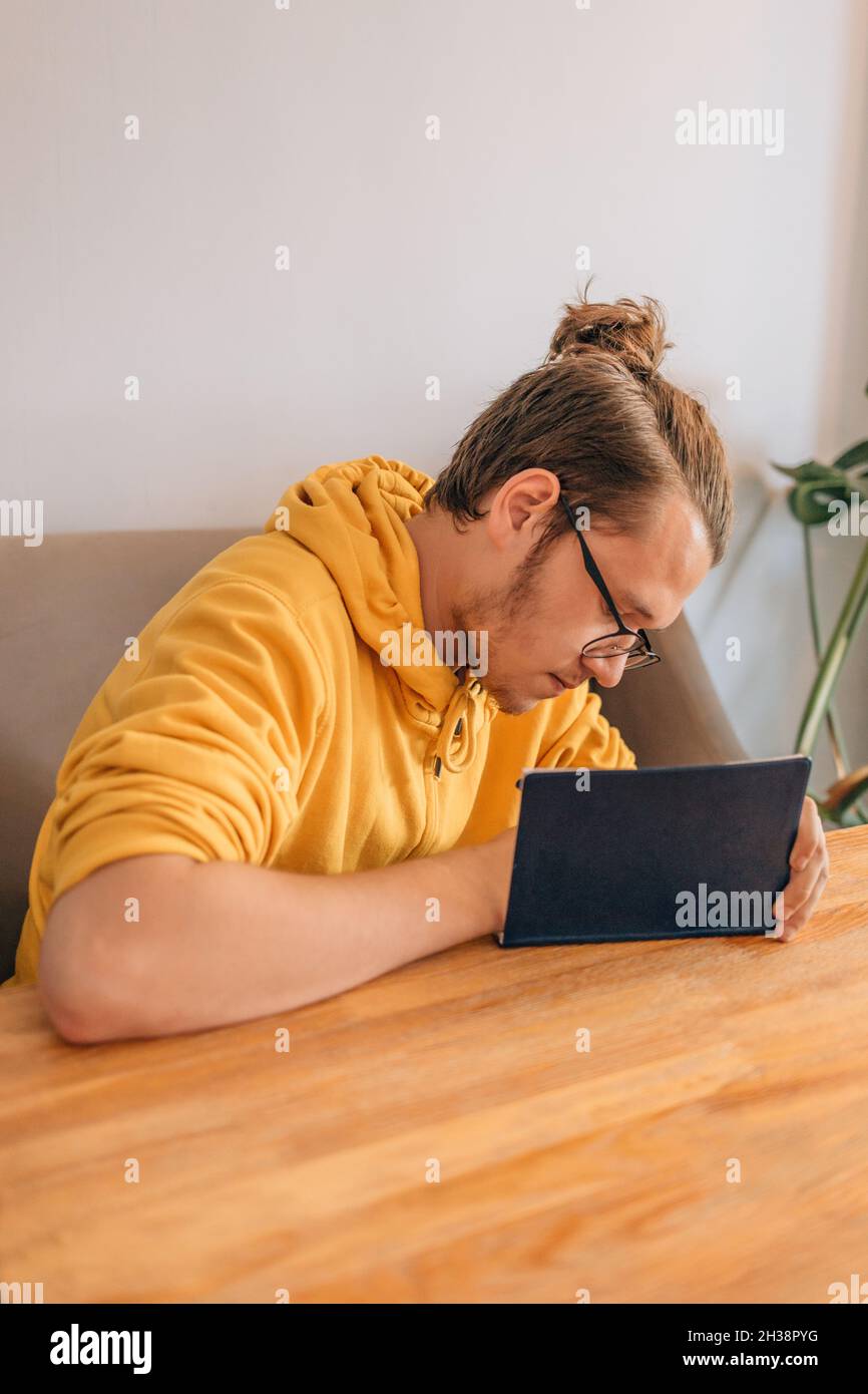 Teenager junger Mann schreibt im Notizbuch. Lifestyle-Vertikalaufnahme. Stockfoto