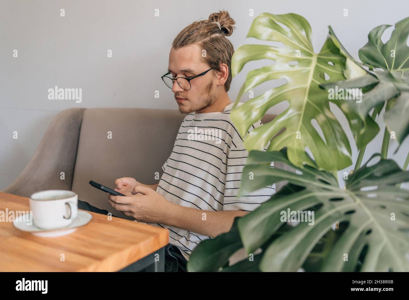 Teenager junger Mann schreibt sms im Café. Stockfoto