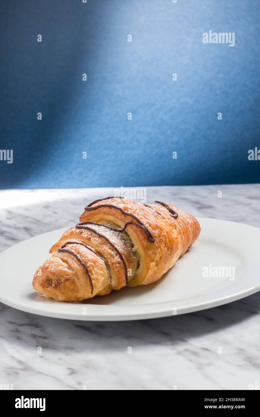 Frisches Croissant auf blauem Hintergrund Stockfoto