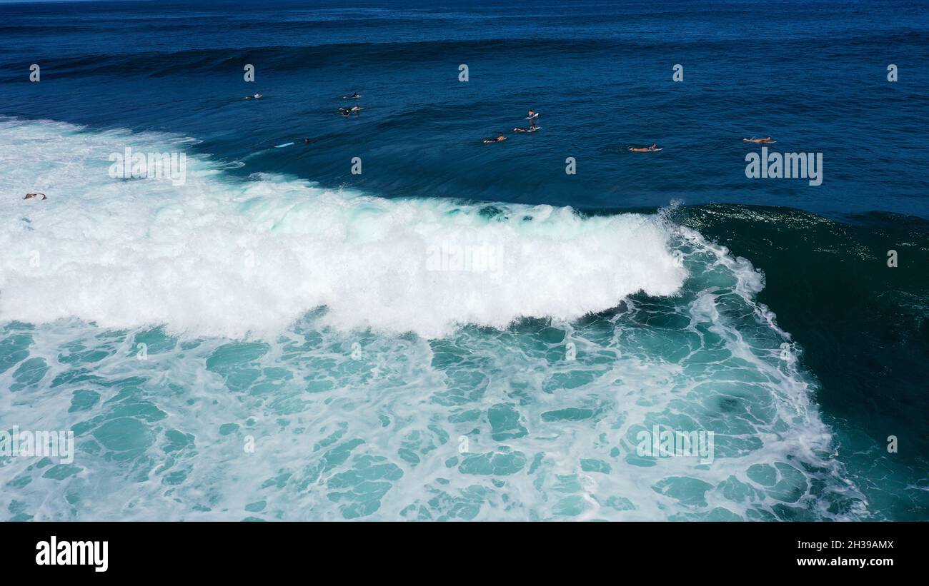 Blick von oben auf die großen Wellen, die auf dem blauen Ozean Rollen. Sonniger Tag über dem Meer am Strand von Uluwatu auf Bali. Stockfoto