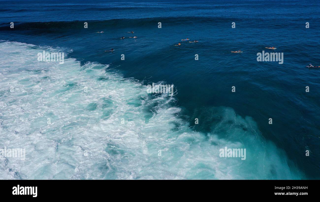 Blick von oben auf die großen Wellen, die auf dem blauen Ozean Rollen. Sonniger Tag über dem Meer am Strand von Uluwatu auf Bali. Stockfoto
