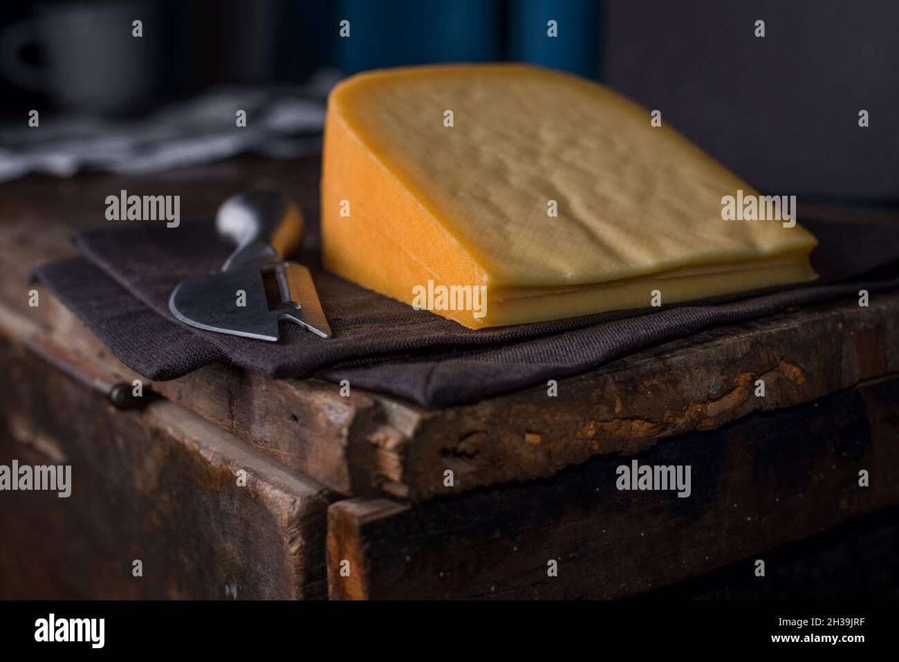 cheddar-Käsestück auf Holztisch Stockfoto