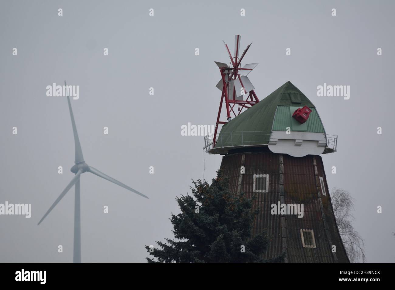 Windmühle und Windenergieanlage. Stockfoto