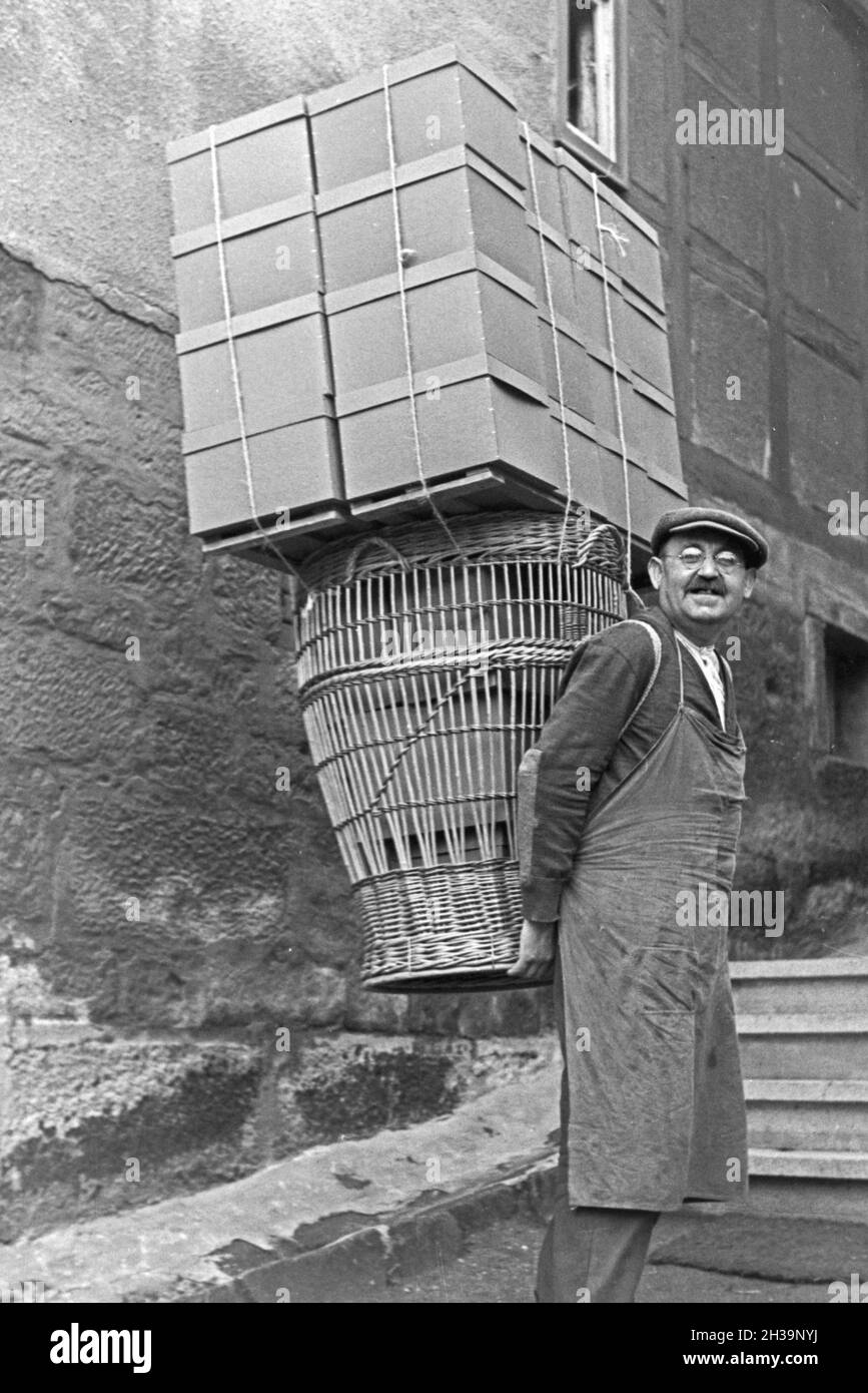 Ein Packer mit Körben und Kästen, Deutschland 1930er Jahre. Einen Packer mit Rucksack Warenkorb und Boxen, Deutschland 1930. Stockfoto