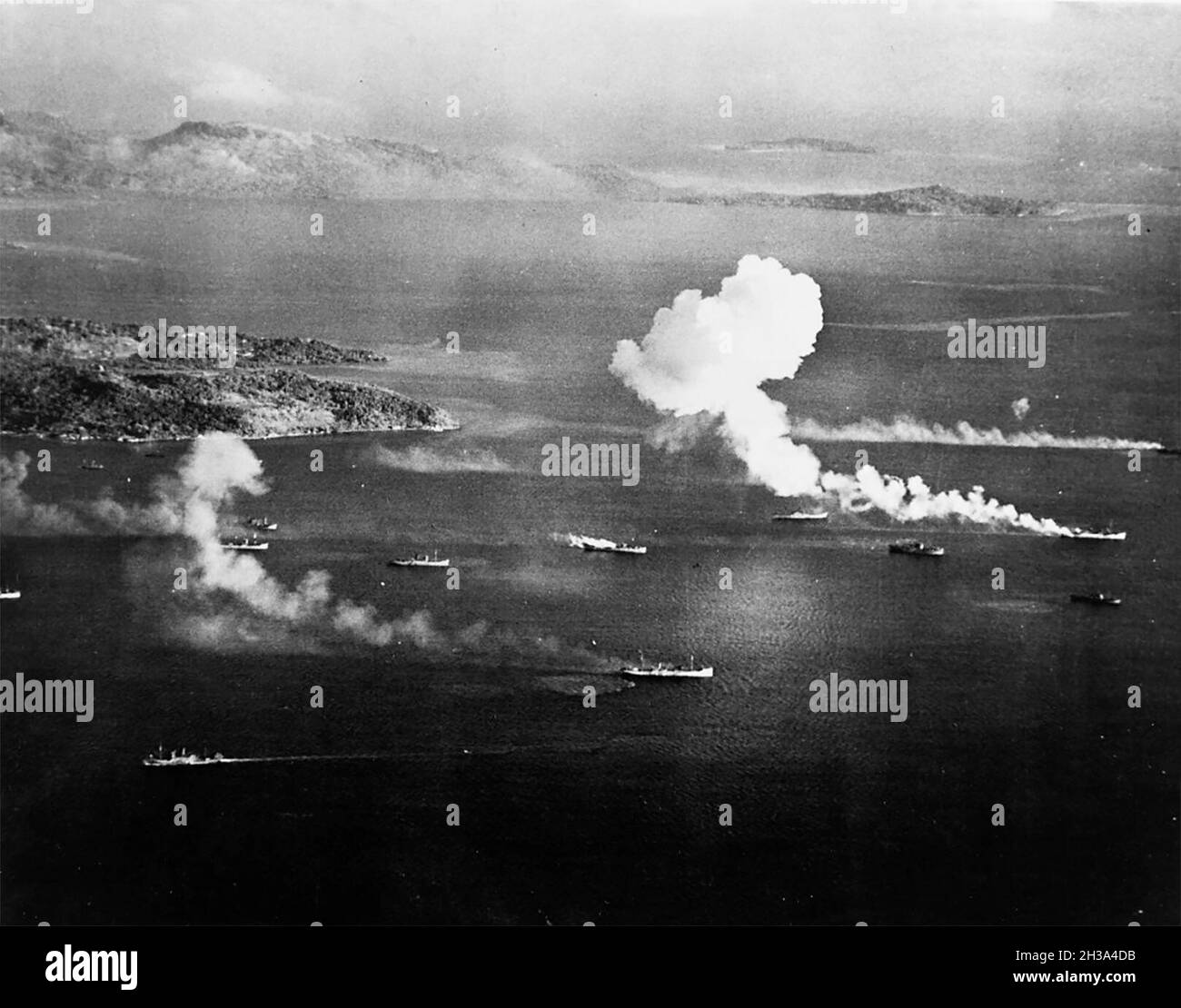 Japanische Schifffahrt unter Luftangriff in Truk Lagoon, wie von einem USS Intrepid (CV-11) Flugzeug am ersten Tag der Überfälle gesehen, 17. Februar 1944. Dublon Island ist links, mit Moen Island im Hintergrund. Vier dieser Schiffe scheinen bis zu diesem Zeitpunkt getroffen worden zu sein. Stockfoto