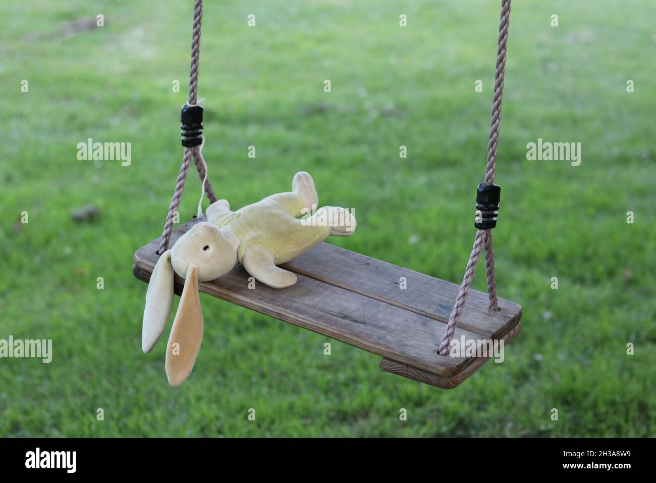 Gefüllter Hase auf Schaukel liegend, Konzept für verlorenes oder vermisstes Kind Stockfoto