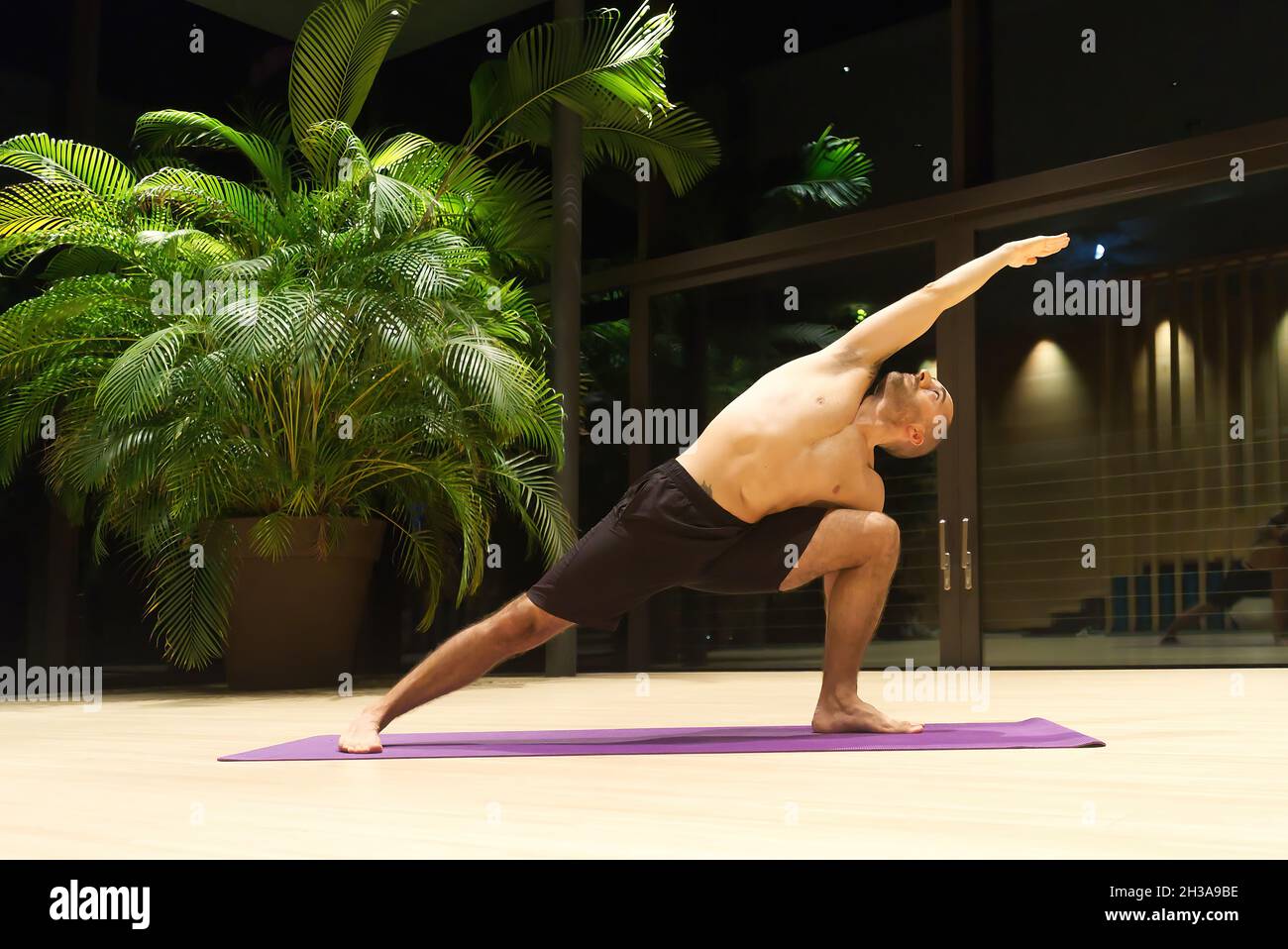 Omar Mura Mann mittleren Alters kaukasischen führt eine Yoga-Position in Innenräumen. Stockfoto