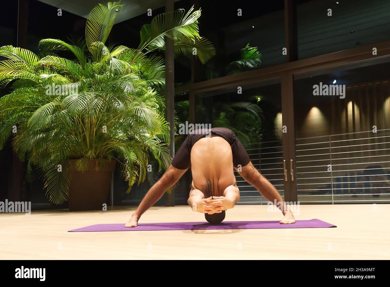Omar Mura Mann mittleren Alters kaukasischen führt eine Yoga-Position in Innenräumen. Stockfoto