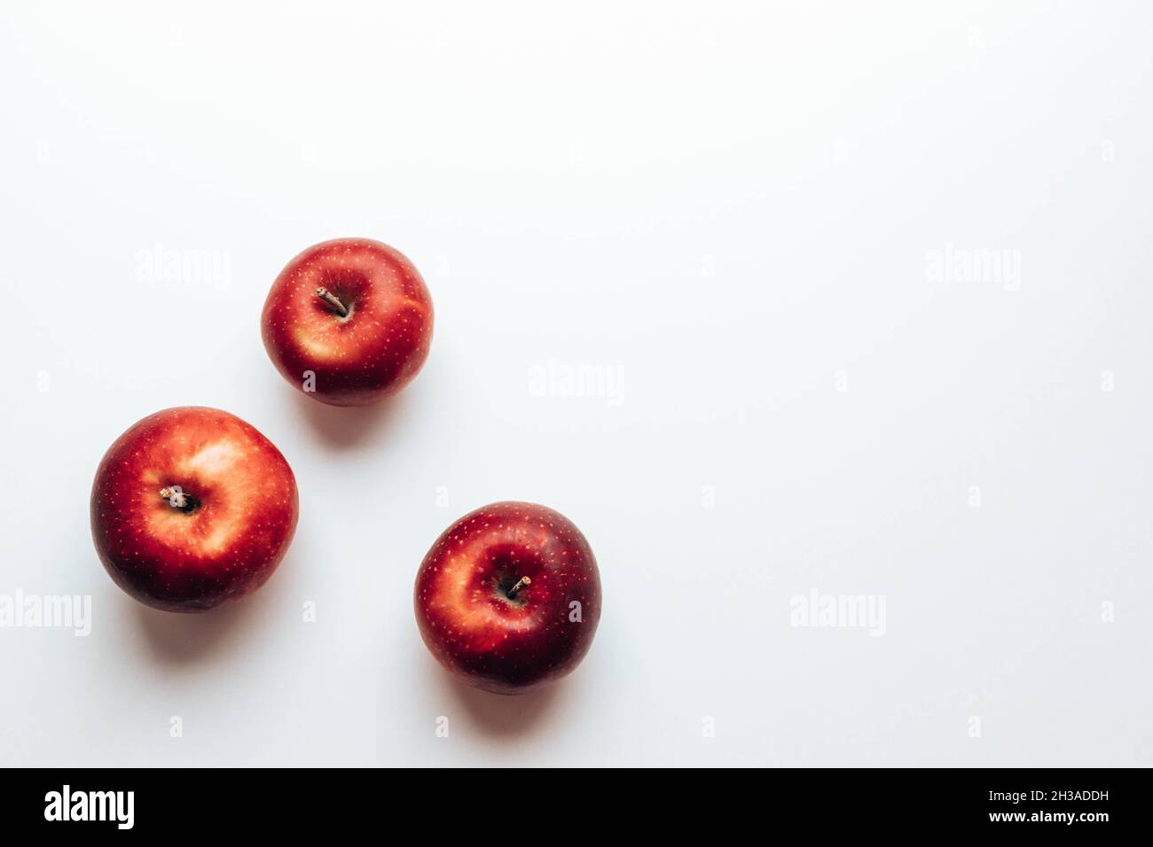 Drei reife, saftige rote Rayal-Galaäpfel auf grauem Hintergrund. Draufsicht. Herbstkomposition. Flach liegend, Draufsicht, Kopierbereich Stockfoto