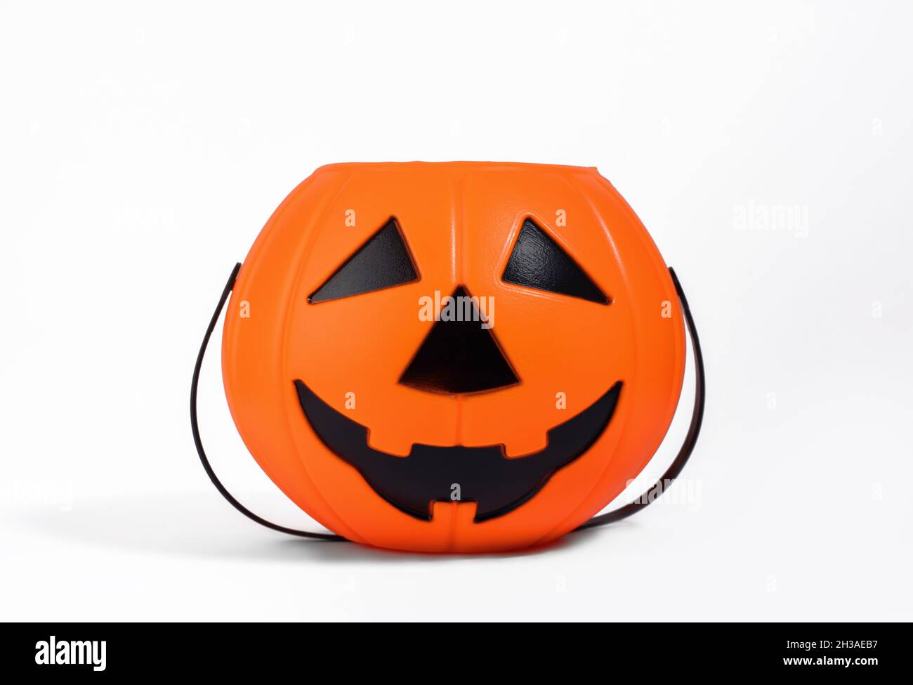 Jack o Laterne orange Korb oder Eimer für Süßigkeiten isoliert auf weißem Hintergrund mit Schatten. Halloween-Feier und Trick-or-Treating-Konzept. Süß Stockfoto